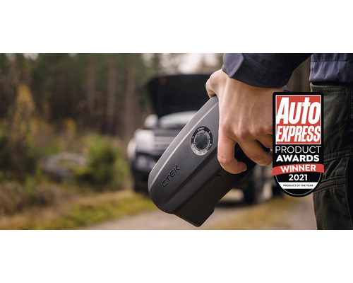 Person hält CTEK Starthilfe vor Auto mit geöffneter Motorhaube, mit Auto Express Product Awards Gewinner 2021 Siegel