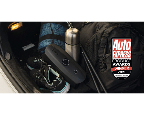 Autobatterieladegerät von CTEK zusammen mit einer Tasche, einer Thermoskanne und Wanderschuhen im Kofferraum