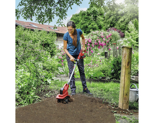 Frau arbeitet mit einer Akku-Bodenhacke im Garten.