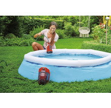 Une femme utilise une pompe de piscine Einhell pour vider une piscine dans le jardin.