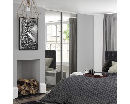 Chambre avec armoire à portes coulissantes, lit et décorations pour une ambiance lumineuse