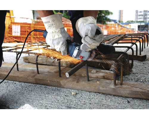 Eine Person schneidet mit einem Winkelschleifer Armierungseisen.