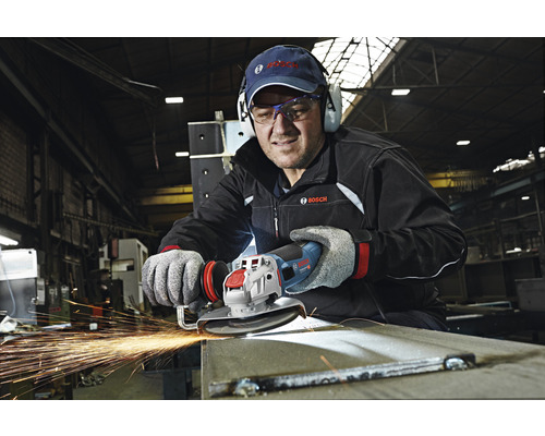 Un homme meule du métal avec une meuleuse d''angle Bosch, des étincelles jaillissent