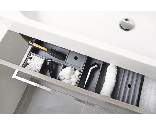 Offene Schublade im Badezimmer mit Kosmetikartikeln und Haarbürste