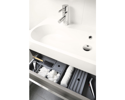 Meuble sous-lavabo avec tiroir ouvert et accessoires de salle de bain