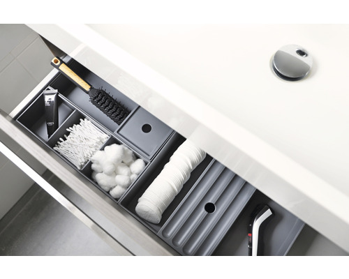 Offene Schublade im Badezimmer mit verschiedenen Pflegeprodukten in Aufbewahrungsboxen