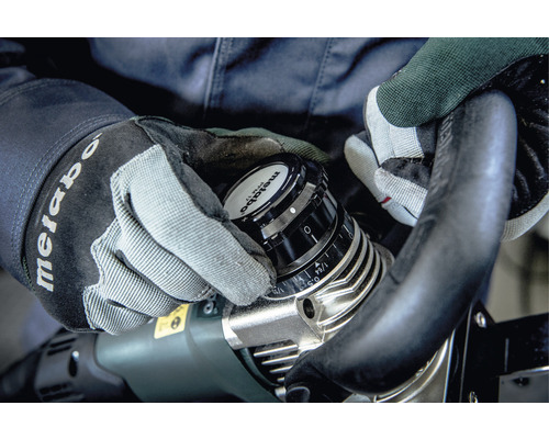 Personne ajustant une fraise Metabo avec des gants