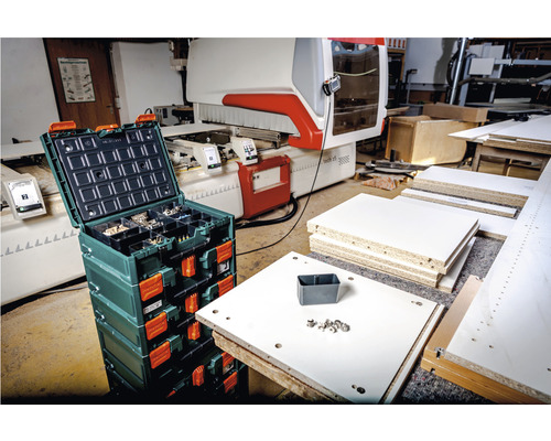 Werkstatt Szene mit Organizerbox, Werkstücken und CNC Maschine im Hintergrund