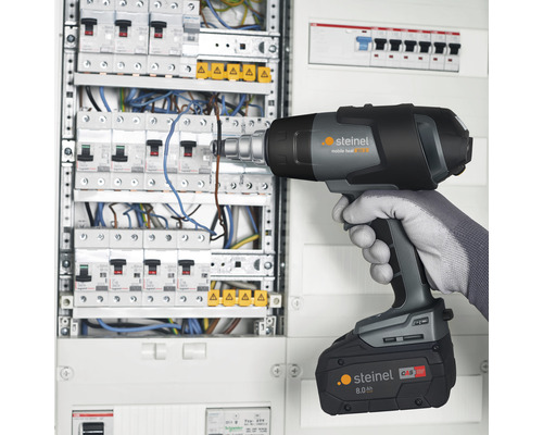 Décapeur thermique sans fil utilisé sur un boîtier de distribution.