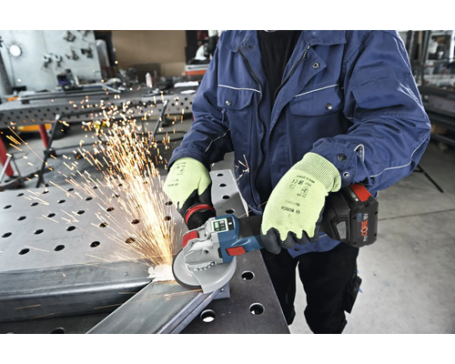 Une personne meule du métal avec une meuleuse d'angle sans fil, ce qui provoque des étincelles.