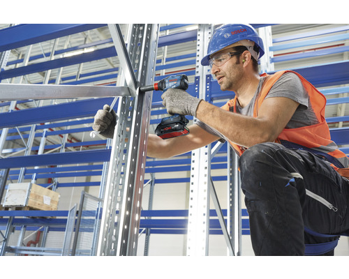 Ein Mann montiert ein Metallregal mit einem Akku-Schlagschrauber von Bosch.