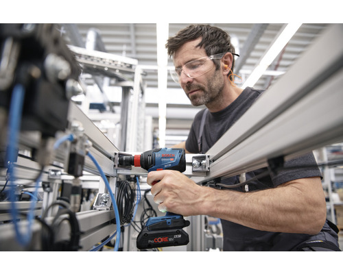 Ein Mann benutzt einen Akku-Schlagschrauber an einer Aluminiumkonstruktion.