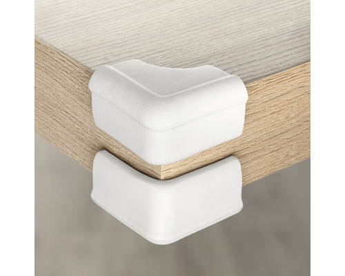 Deux protections d''angle blanches sur un bord de table pour protéger des chocs