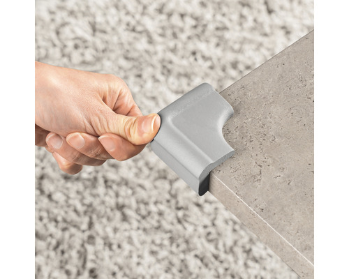 Eckenschutz aus Schaumstoff wird an einer Tischkante angebracht