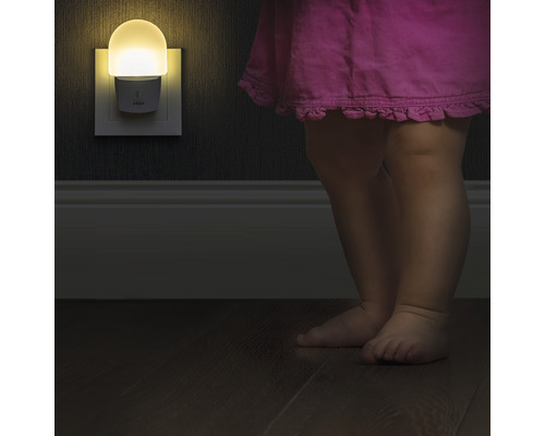 Veilleuse dans une prise à côté d''un enfant dans une chambre