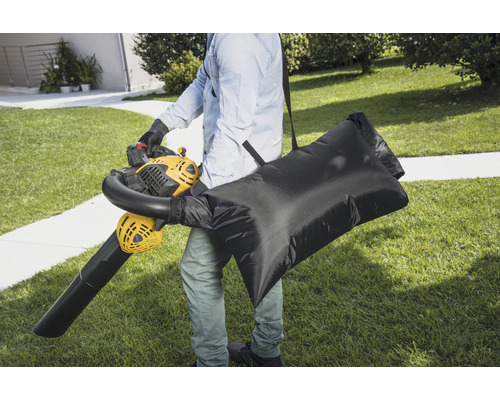 Person mit Laubbläser und Fangsack im Garten