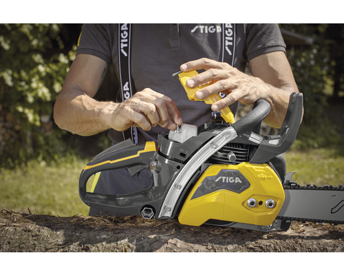 Une personne remplit d''huile une tronçonneuse Stiga.