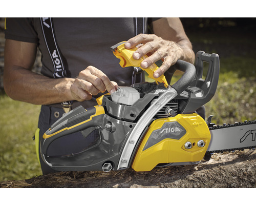 Une personne remplit une tronçonneuse Stiga d''huile.