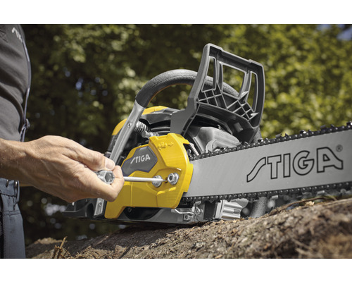 Une personne serre la chaîne d''une tronçonneuse Stiga avec une clé.