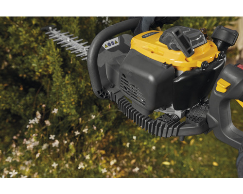 Motorbetriebene Heckenschere vor Pflanzen