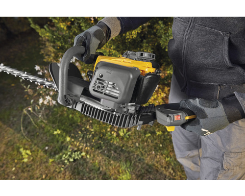 Person bedient eine Heckenschere zum Heckenschneiden