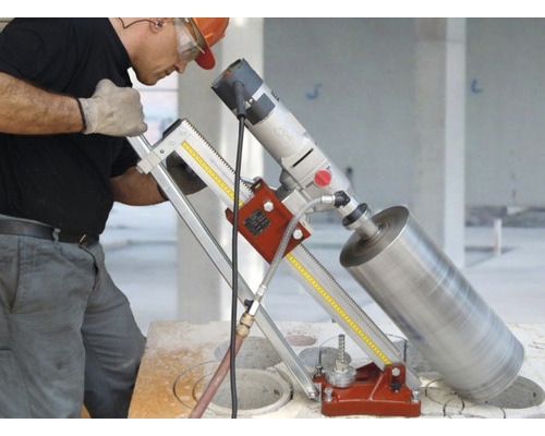 Ein Mann bedient eine Kernbohrmaschine auf einer Baustelle.