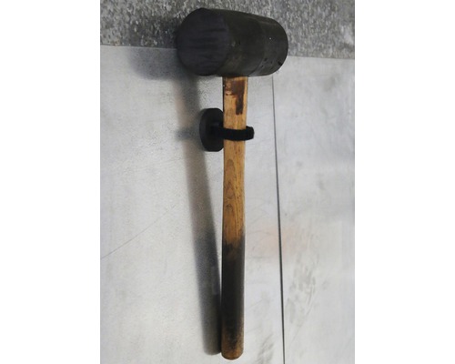 Maillet en caoutchouc avec manche en bois sur un support mural