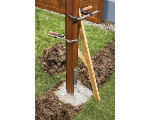 Poteau en bois fixé dans une fondation en béton avec des serre-joints