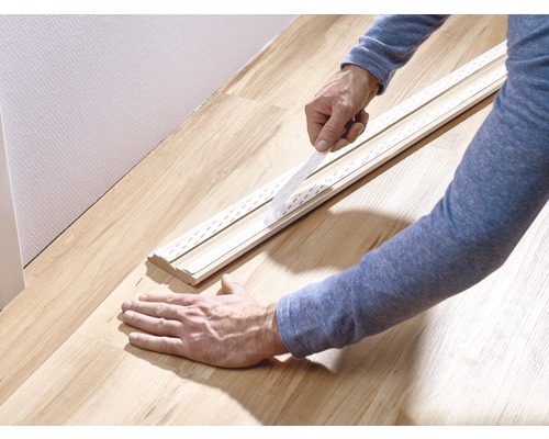 Anbringen einer Sockelleiste mit Klebeband am Boden