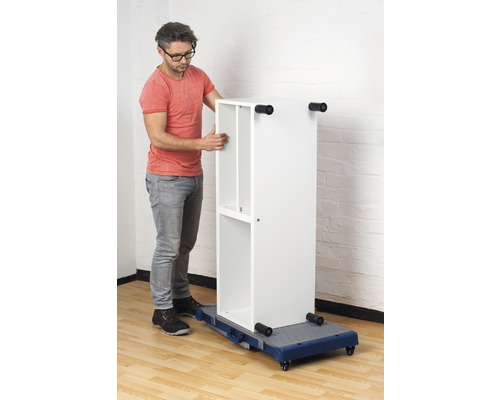 Un homme déplace une étagère blanche sur une planche à roulettes.