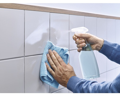 Reinigung von Fliesen mit Sprühflasche und Tuch