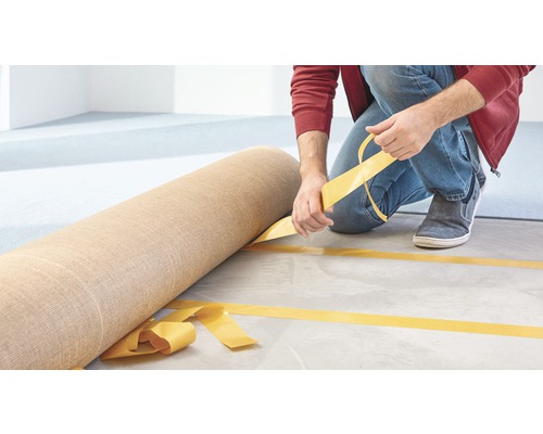 Pose d''un rouleau de moquette avec du ruban adhésif double face