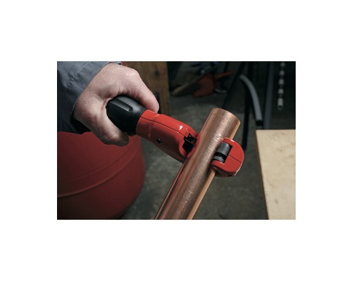 Coupe-tube en cours d''utilisation sur un tuyau en cuivre