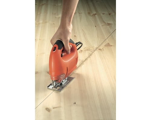 Une personne coupe une planche de bois le long d''une ligne avec une scie sauteuse.