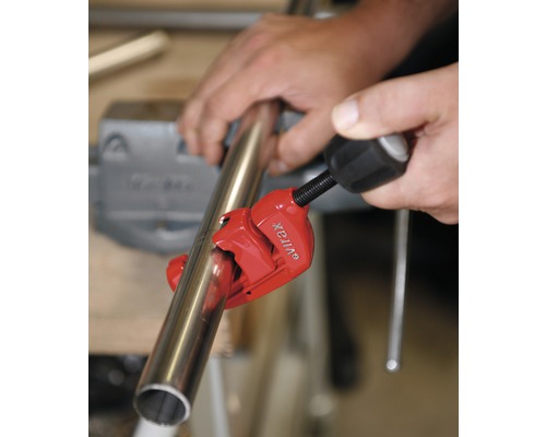 Coupe-tube en cours d''utilisation pour couper un tube métallique