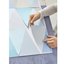 Personne arrangeant des motifs de papier peint triangulaires
