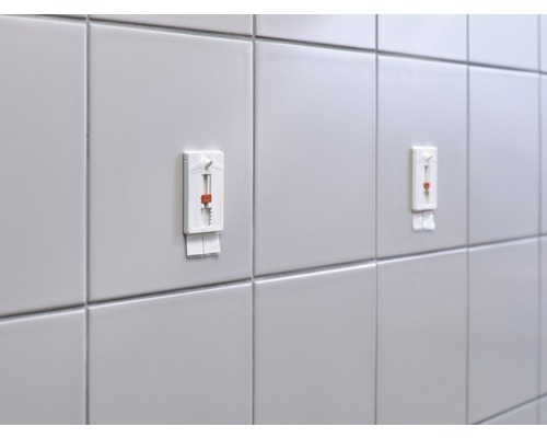 Mur carrelé avec deux systèmes de nivellement de carreaux fixés