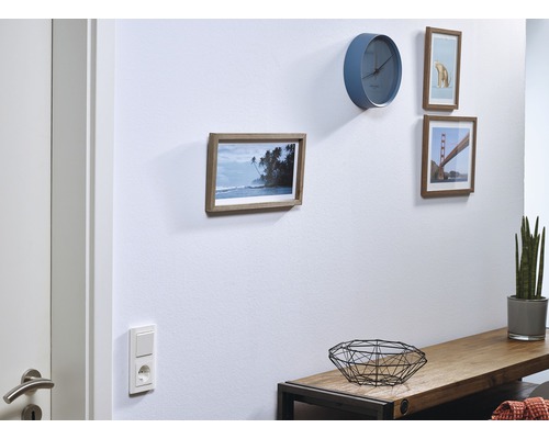 Wohnraum mit Wanduhr und gerahmten Bildern