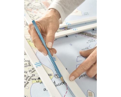 Eine Person, die mit einem Bleistift eine Linie auf einer Seekarte zieht