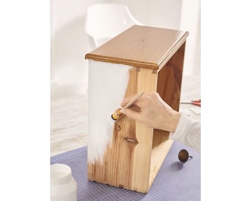 Holzkiste wird mit Farbe gestrichen