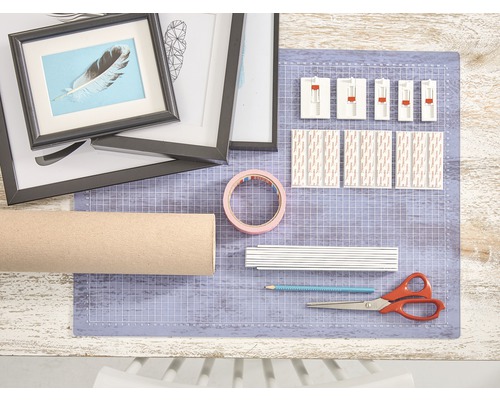 Basteltisch mit Bilderrahmen, Kartonrolle, Klebeband, Schere, Bleistift und Klebestreifen