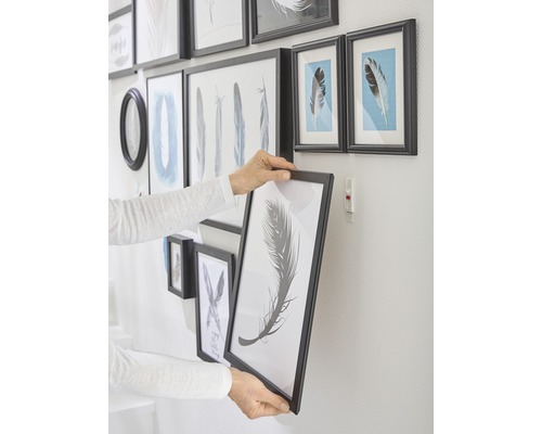 Person hängt Bilderrahmen an die Wand