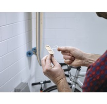 Un homme tient un support en bois pour équipements sportifs dans sa main