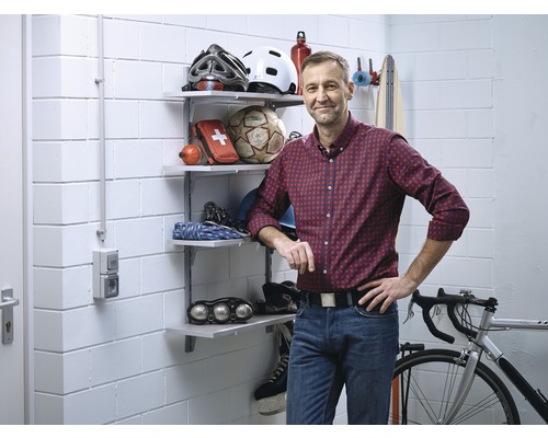 Cave organisée avec des étagères, un vélo et des articles de sport.