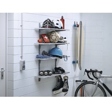 Système d''étagères avec équipement de sport sur un mur, comprenant des casques, un ballon, une trousse de premiers secours, un skateboard, un vélo et des patins à glace