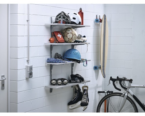 Système d''étagères avec équipement de sport sur un mur, comprenant des casques, un ballon, une trousse de premiers secours, un skateboard, un vélo et des patins à glace