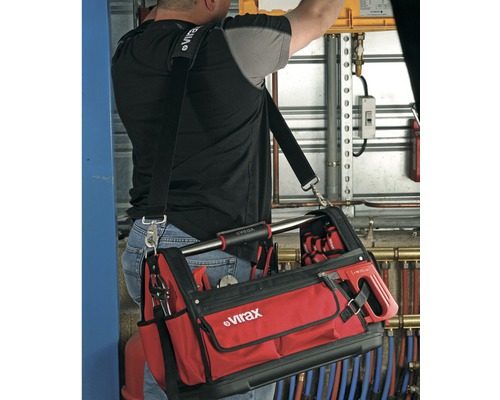 Handwerker mit Virax Werkzeugtasche über der Schulter, gefüllt mit Werkzeugen.