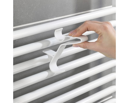 Main fixant un crochet pour serviette sur un radiateur