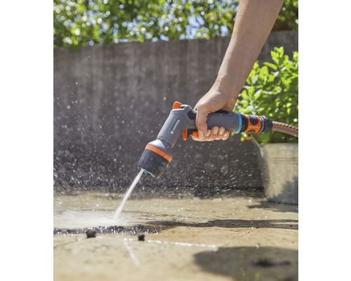 Eine Person benutzt eine Gardena Mehrzweckbrause zum Bewässern einer Fläche.