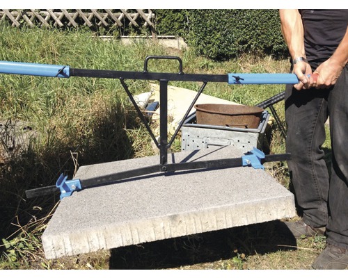 Personen tragen eine Betonplatte mit einem Steinheber.